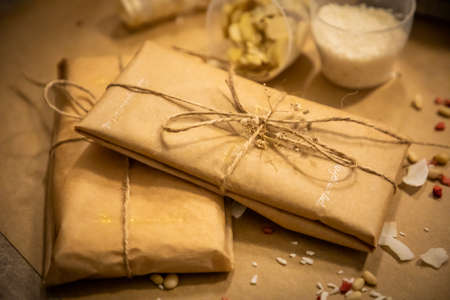 Handmade chocolate with fresh and dried fruits in wrapping on light paper background in rustic style