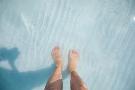 Girl feet steping in turquoise water into the white beach of Salda Lake, Burdur, Turkeyの写真素材