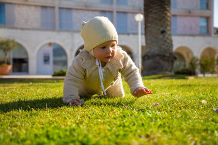Cute baby girl outdoor in spring time on grassの写真素材