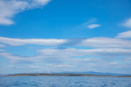 View from water of rocky shore of island in Croatiaの写真素材