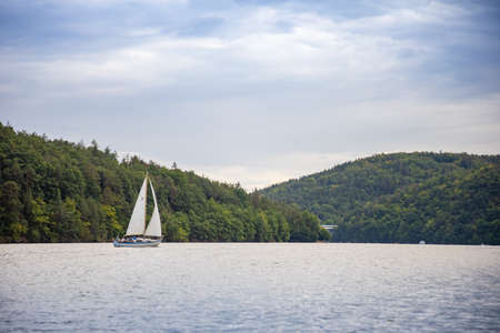White yacht with sail on Lake Slapy, Bohemia, Czech Republic