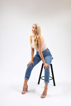 Beautiful young blonde woman is posing on white backgroundの写真素材
