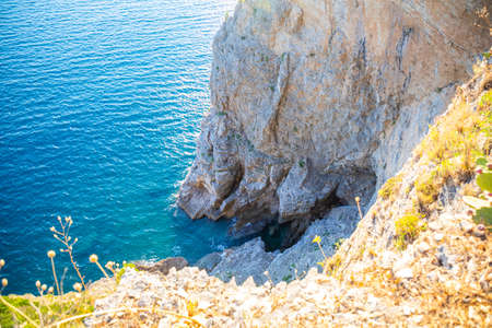 Top view of the rocky coastline cliff near Mogren Fort in Budva, surrounded by amazing turquoise...