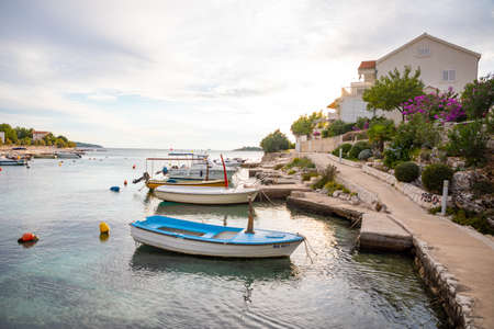 Rogoznica, Croatia - October 12, 2021: Beautiful area Lozica of Rogoznica town with sandy beach, white architecture and fishing boats at sunset time, Croatia.のeditorial素材