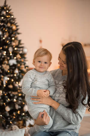 Happy family mother and child daughter near Christmas tree at home