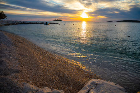Beautiful area Lozica of Rogoznica town with sandy beach, white architecture and fishing boats at sunset time, Croatia.の写真素材