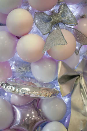 Beautiful christmas decor in silvery pink tones, christmas lights and toys on a concrete background