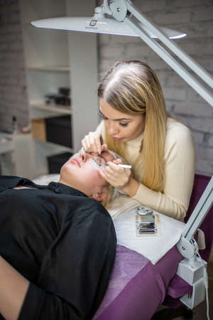Eyelash extension procedure in beauty salon. Lashes close up. Concept spa lash.
