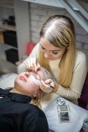 Eyelash extension procedure in beauty salon. Lashes close up. Concept spa lash.の写真素材