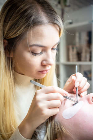 Eyelash extension procedure in beauty salon. Lashes close up. Concept spa lash.
