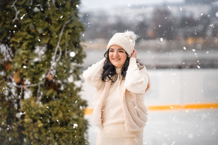 Beautiful girl having fun while skating at ice rink on Prague castle background, Czech republic,...