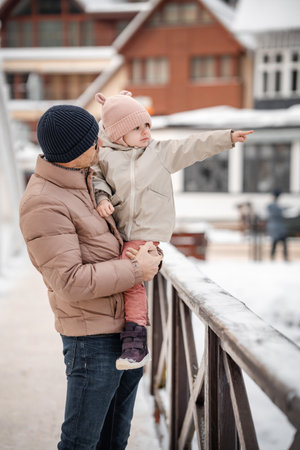 Young father and his daughter having fun on snowy winter day in small town of Czech republic. High quality photoの写真素材