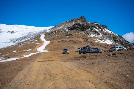 Aktash, Russia - May 9, 2022: View from a repeater on snowy tops of Altai mountains. Cars on top of mountain near Aktash town, Russia. High quality photoのeditorial素材