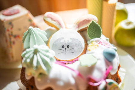 Easter cake decorated gingerbread in the form of a rabbit on table in home kitchen. Church icons and...