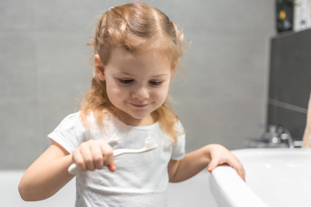 Happy toddler girl brushing teeth in the bath. High quality photoの写真素材