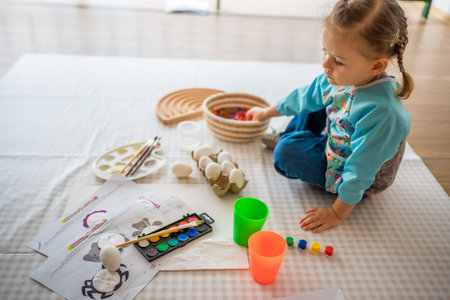 Little girl paints with colored paints. Sensory development and experiences, themed activities with children, fine motor skills development. High quality photoの写真素材