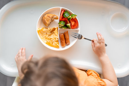 Little girl have a balanced breakfast in home kitchen in the morning. high quality photoの写真素材
