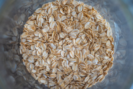 Rolled oats in a glass bowl - top view. On a grey background. High quality photo