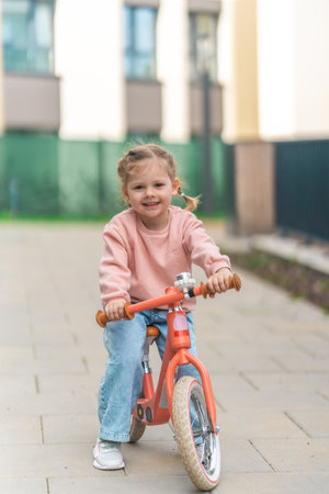Little girl riding balance bike in the courtyard of the residence in Prague, Europe. High quality photoの写真素材
