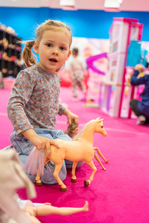 Prague, Czech Republic - April 27, 2023: Little girl playing in childrens playroom with Barbie toys and Hot Wheels in the Letnany shopping center in Prague, Czech Republic. High quality photoのeditorial素材