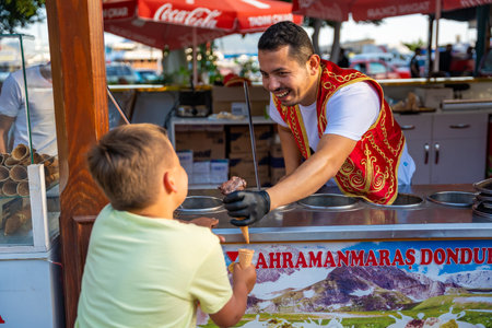 Kas, Turkey - June 7, 2023 : Seller of dondurma or turkish ice cream doing a spectacular show to the kids customer in a street shop in Kas town, Turkey. High quality photoのeditorial素材