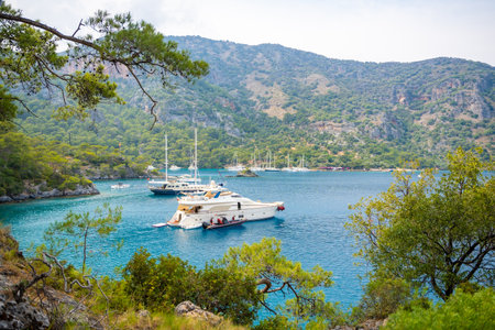 Fethie, Turkey - June 4, 2023: Beautiful sea coast Cleopatra Bath Bay near Fethie, Turkey. Summer landscape with moor yachts, clear blue water and pine trees. High quality photoのeditorial素材