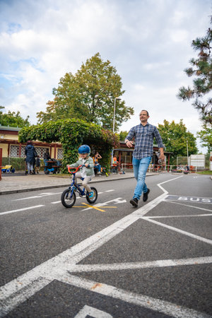 Prague, Czech republic - October 10, 2023: Young happy father teaches child daughter to ride public bike on traffic playground in Prague, Czech republic, Europe. High quality photoのeditorial素材