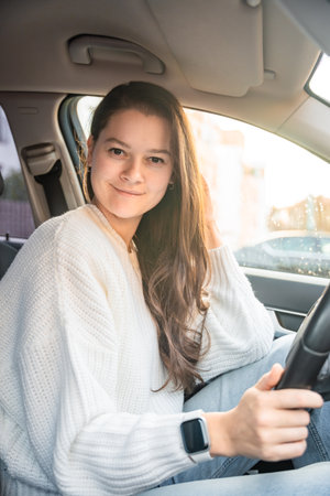 Portrait of young woman inside car interior. The car as a place in which a significant part of...