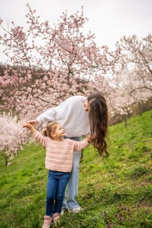 Young woman with little daughter in a blooming pink and white garden Petrin in Prague, spring time in Europe. High quality photoの写真素材