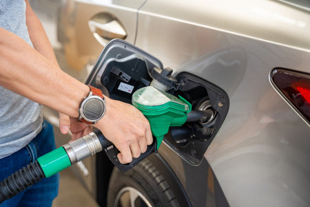 Close up view of driver hand fills up expensive gasoline in self-service filling station in Europe. High quality photoの写真素材