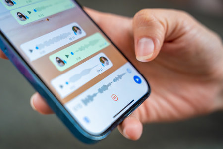 Prague, Czech republic - May 2, 2024: Woman holding iPhone with chat application WhatsApp on the screen, using mobile application for voice messaging at home. High quality photoのeditorial素材