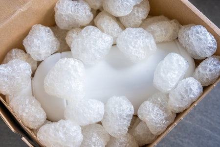 Eco packaging of parcels and white biodegradable filler. Box is filled with a filler safety for...