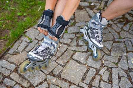 Close up view of feet in inline skates of roller skater woman. Rollerblading in park. Outdoor...