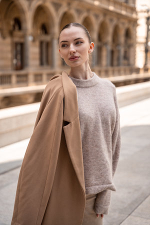Young beautiful woman wearing coat walking in the city center of Prague, Czech republic, Europeの写真素材