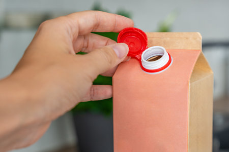 Long-life cardboard container from recycling materials with stationary plastic cap. Cap remains...