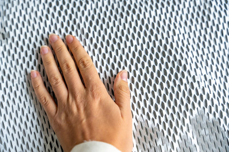 Hand on texture of corrugated white paper for safe transportation, in which the goods brought by the courier delivery service are wrapped, environmental packaging concept. High quality photoの写真素材