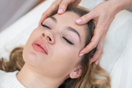 Close up view of healer hands performing by lightly touched therapy on young woman head, stimulating positive change thoughts and emotions. Alternative medicine concept. High quality photoの写真素材