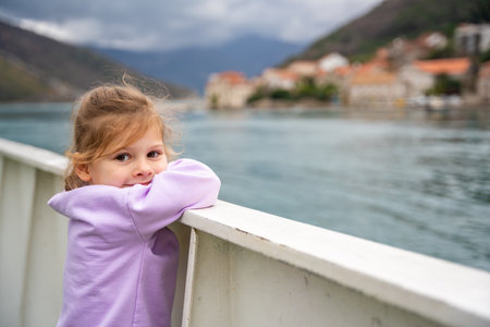 Little girl traveling with family by ferry. Crossing from one bank to another of Kotor bay in Montenegro. High quality photoの写真素材