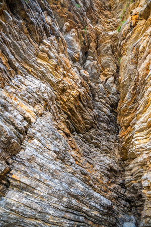 Layered rock texture in Budva, Montenegro. Sedimentary rocks with rugged surface of gray and brown. Natural formation of layers and cracks, geological structure. High quality photoの写真素材