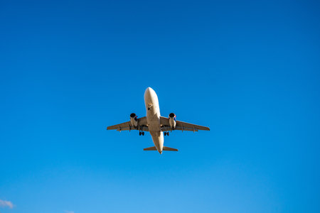 Underside view of an airplane flying through the sky, showcasing aviation technology, flight path,...