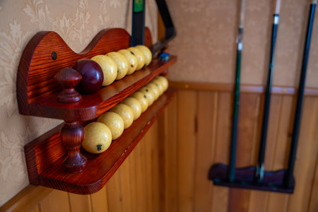 Home billiard setup with white balls, red cue ball, triangle rack, and cues neatly arranged. Concept of indoor recreation and personal hobby space. High quality photoの写真素材