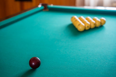 Initial billiard ball arrangement with white balls in a triangle and red cue ball ready for the...