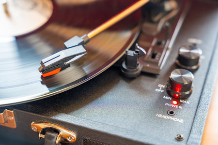 Close-up of record player needle tracking vinyl grooves during playback. Analog sound detail...