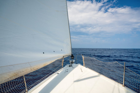 Bow of a sailing yacht cutting through the sea with sails fully open near Croatia. Freedom, motion,...