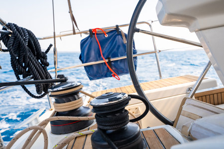 Cockpit of a sailing yacht with steering wheel, winches and ropes during navigation near Croatia....