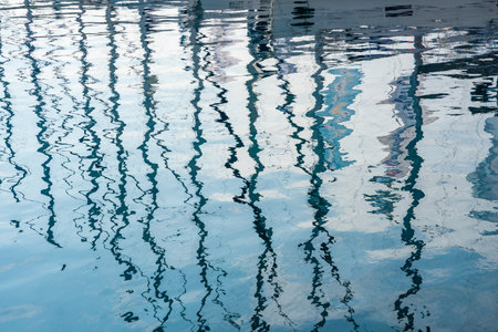 Reflection of sailing yachts moored in a marina on Hvar Island, Croatia, shimmering on the surface of the sea. Tranquility, summer atmosphere and nautical lifestyle. High quality photoの写真素材