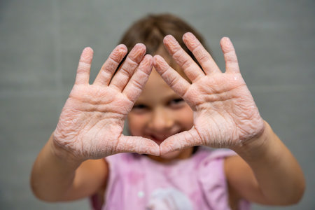 Close-up of a child wrinkled hands after spending a long time in water. Concept of childhood,...