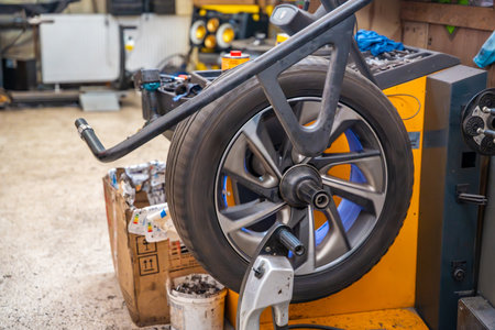Car wheel rotating on a balancing machine during seasonal tire service at an auto workshop. Essential step to ensure smooth driving and tire longevity before winter installation. High quality photoの写真素材