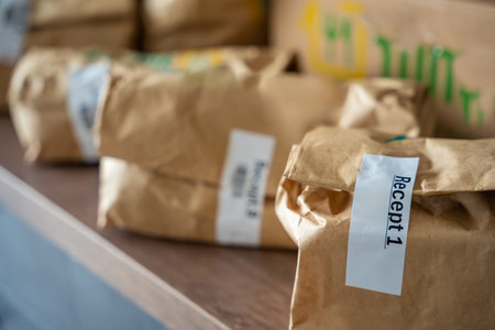 Close-up of brown paper bags with meal kits labeled Recept or Recipe. Subscription-based food...