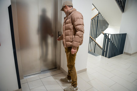Man opening the door to a residential building. Daily routine in a modern apartment complex.